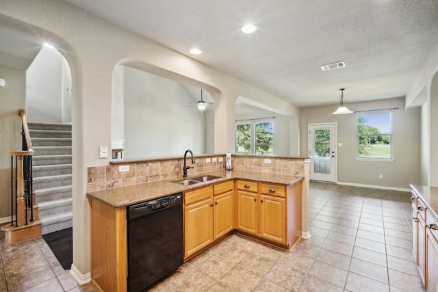 kitchen featuring light stone countertops, decorative backsplash, black dishwasher, and sink