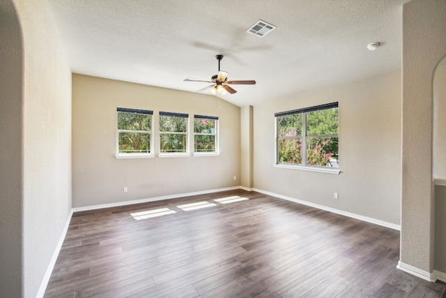 empty room with a textured ceiling, ceiling fan, and dark hardwood / wood-style flooring