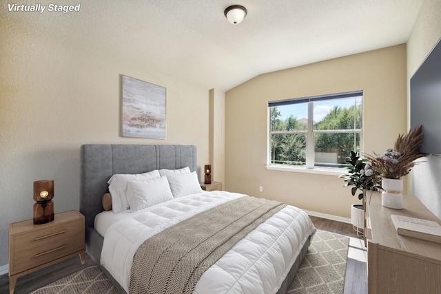 bedroom with dark hardwood / wood-style floors and vaulted ceiling