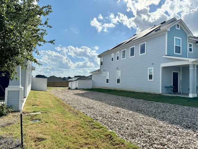 view of home's exterior with a lawn and a storage shed