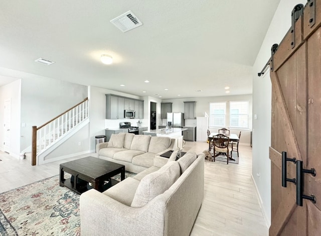 living room with light hardwood / wood-style flooring and a barn door