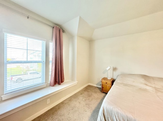 bedroom featuring light carpet and vaulted ceiling