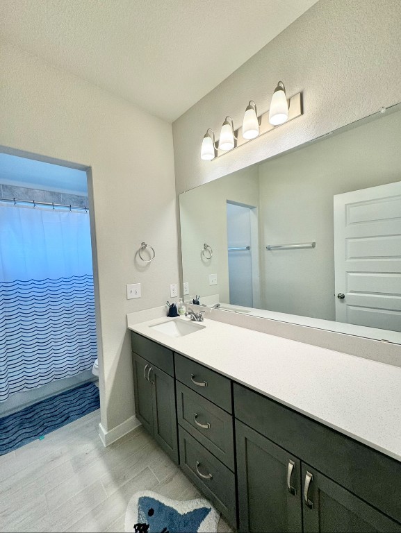 bathroom featuring walk in shower, vanity, and toilet