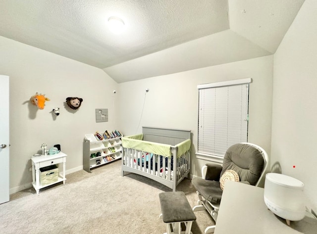 bedroom featuring carpet floors, a nursery area, a textured ceiling, and vaulted ceiling