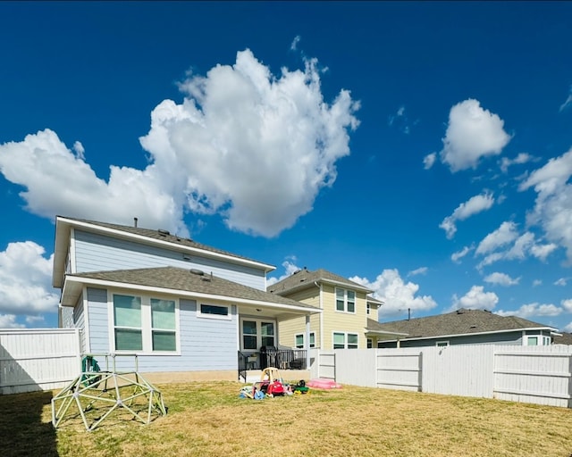 rear view of property featuring a lawn