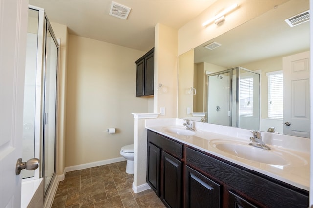 bathroom featuring toilet, vanity, and a shower with shower door