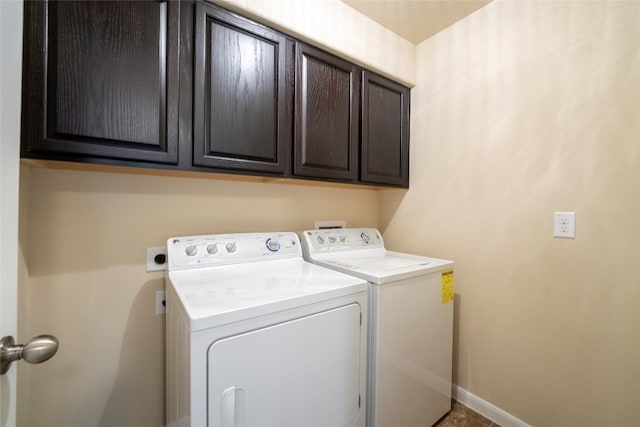 laundry room with washer and clothes dryer and cabinets