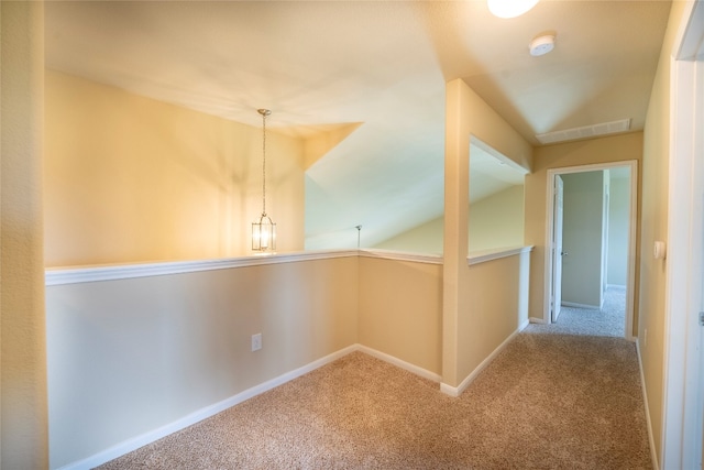 corridor featuring vaulted ceiling and carpet flooring