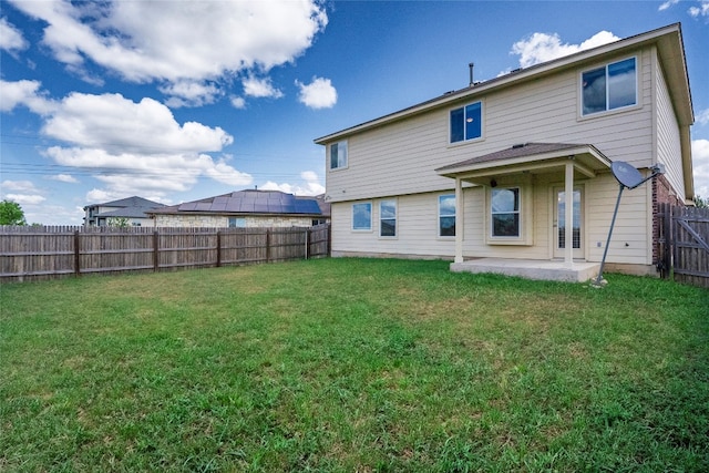 rear view of property featuring a patio, a lawn, and french doors