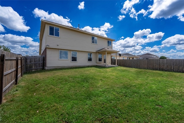 rear view of property with a yard