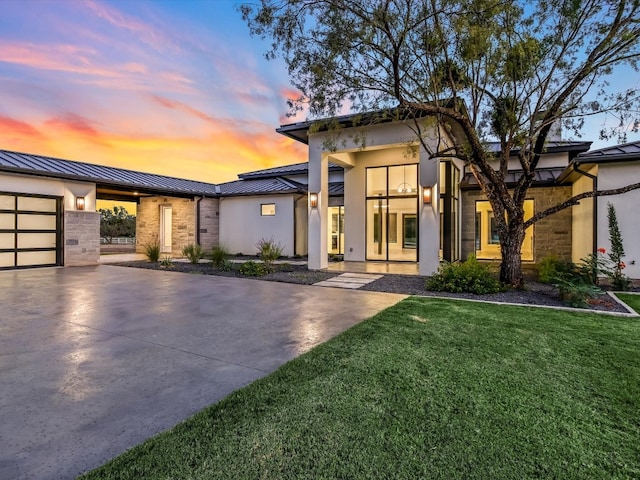 view of front of property featuring a garage and a lawn