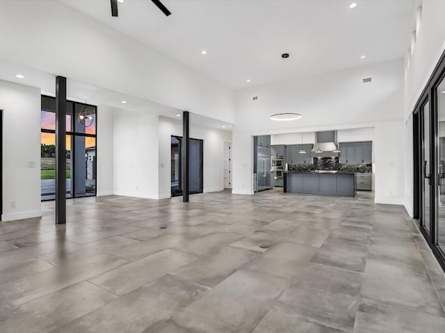 unfurnished living room featuring a towering ceiling