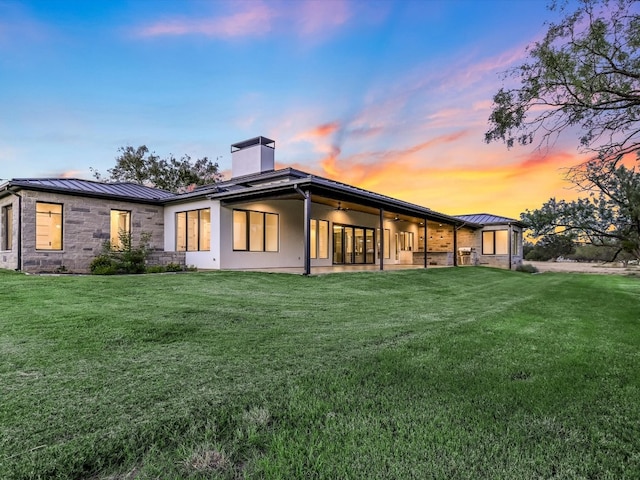 back house at dusk with a yard