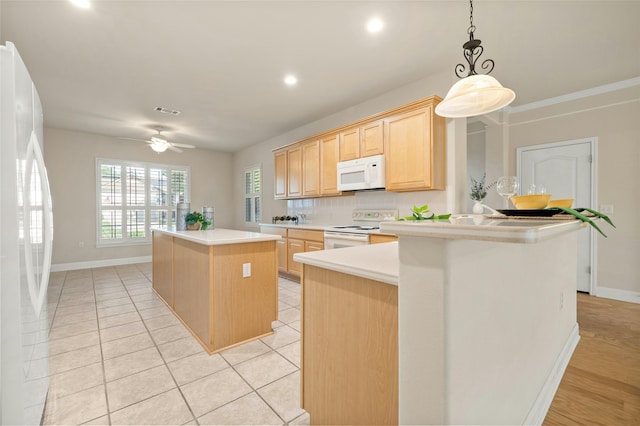 kitchen with kitchen peninsula, light brown cabinets, white appliances, and ceiling fan