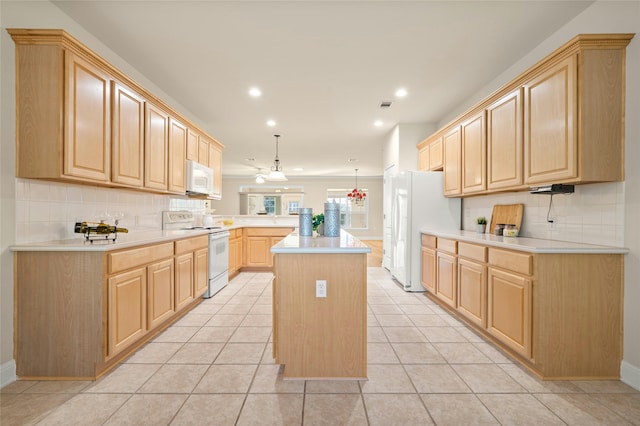 kitchen with a center island, pendant lighting, white appliances, light brown cabinetry, and light tile patterned floors