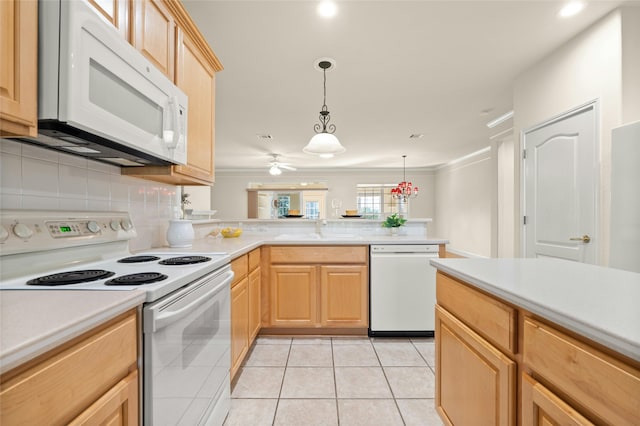 kitchen featuring light brown cabinetry, white appliances, pendant lighting, and sink