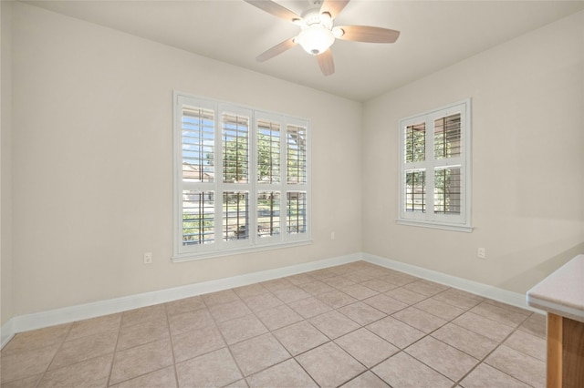 tiled empty room featuring ceiling fan and plenty of natural light