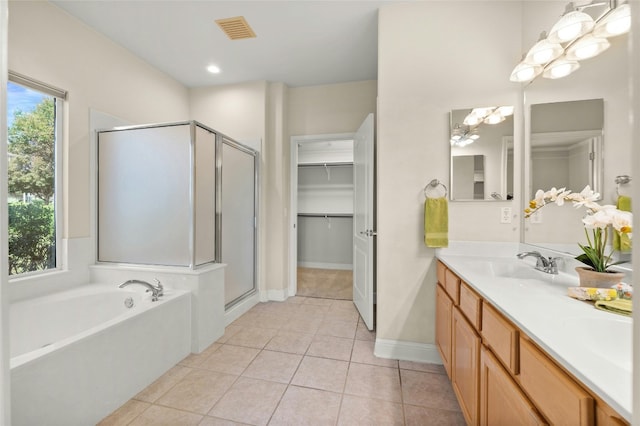 bathroom featuring tile patterned flooring, shower with separate bathtub, and vanity