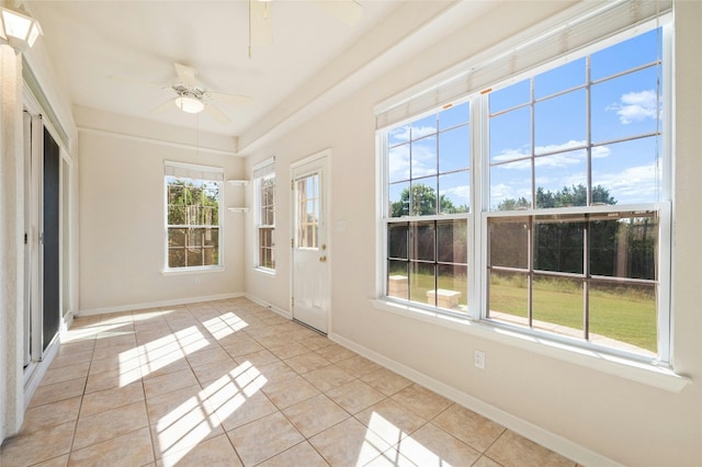 unfurnished sunroom featuring ceiling fan