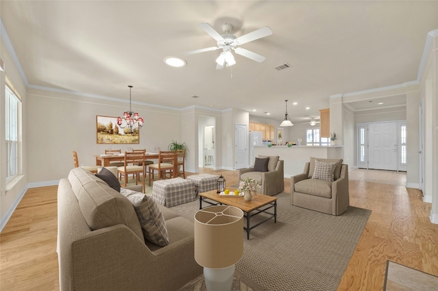 living room featuring ornamental molding, ceiling fan with notable chandelier, and light wood-type flooring