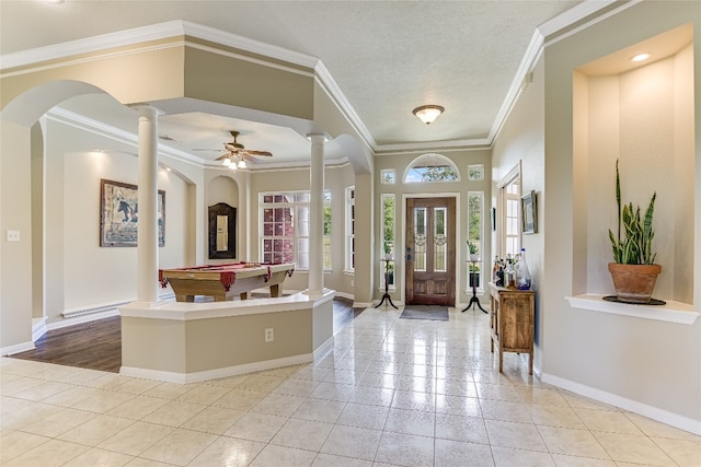 foyer featuring pool table, a textured ceiling, decorative columns, ornamental molding, and ceiling fan