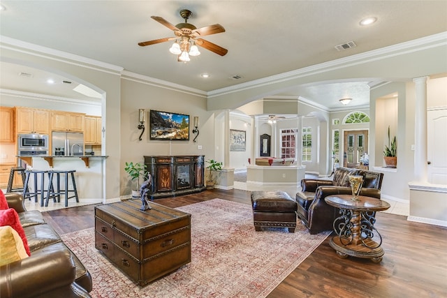 living room with ceiling fan, hardwood / wood-style flooring, and crown molding