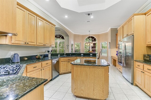 kitchen with light brown cabinets, kitchen peninsula, appliances with stainless steel finishes, and a kitchen island