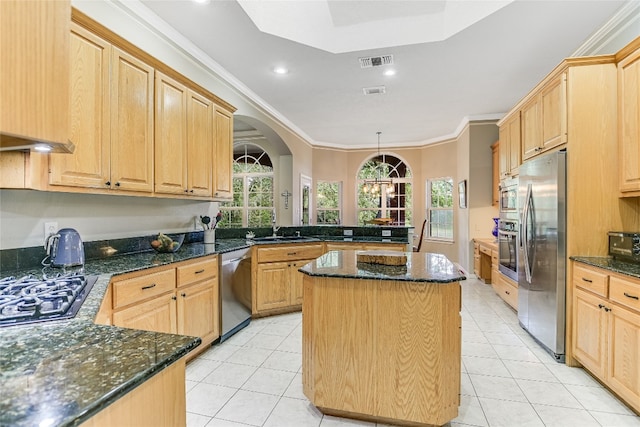 kitchen with appliances with stainless steel finishes, sink, a center island, light brown cabinetry, and kitchen peninsula