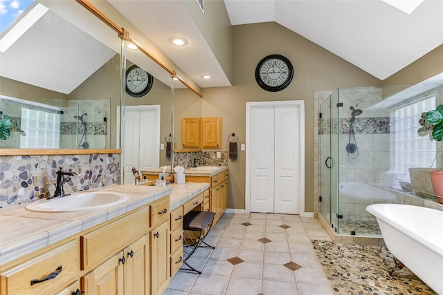 bathroom featuring lofted ceiling, independent shower and bath, tile patterned flooring, and vanity