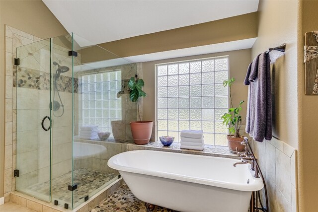 bathroom with independent shower and bath and tile patterned floors