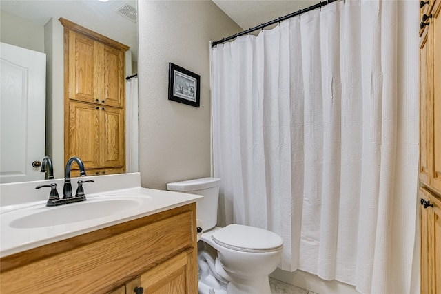 bathroom with a shower with curtain, vanity, tile patterned flooring, and toilet