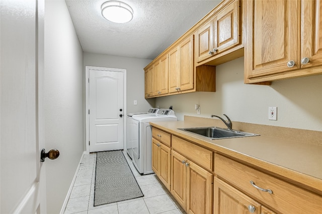 laundry room featuring washer and clothes dryer, a textured ceiling, light tile patterned floors, sink, and cabinets