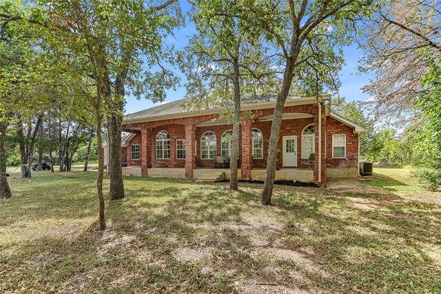 view of front of property featuring central AC unit, a front yard, and a porch