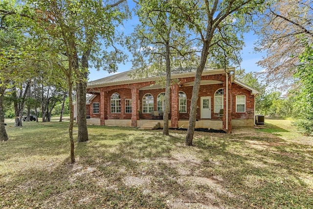 view of front of home with central AC unit and a front lawn