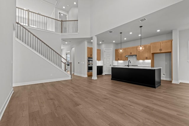 6512 Cowman Way, Austin, TX 78747 - unfurnished living room with light wood finished floors, stairs, recessed lighting, and a high ceiling