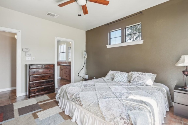 bedroom featuring ensuite bath, ceiling fan, and tile patterned flooring