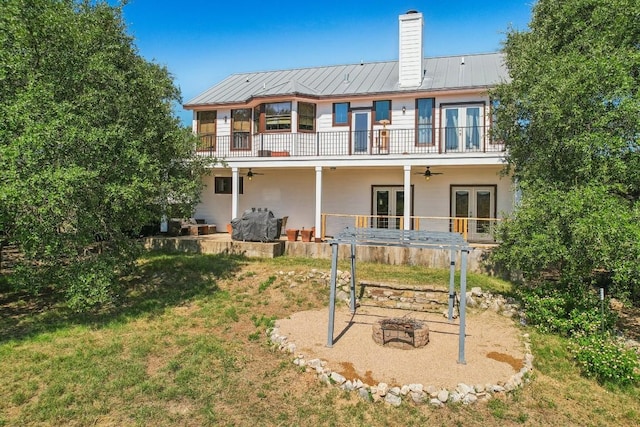 back of property featuring a yard, french doors, and a balcony