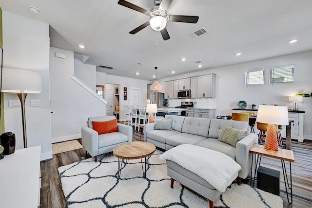 living room with ceiling fan and hardwood / wood-style flooring