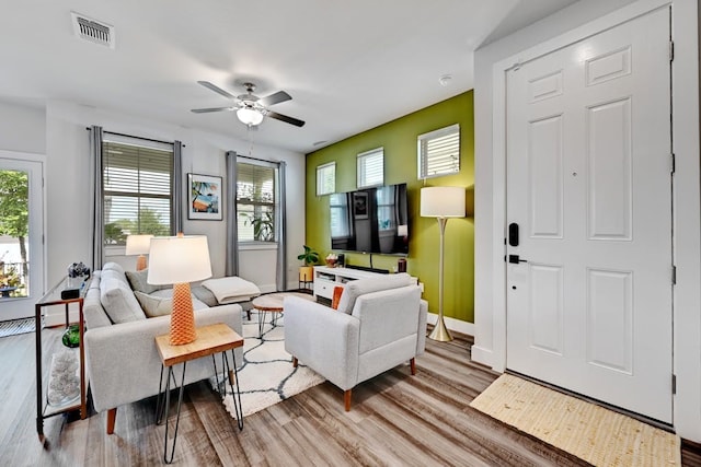 living room with ceiling fan and light hardwood / wood-style flooring