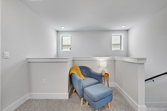 sitting room featuring light colored carpet and plenty of natural light