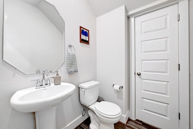 bathroom with toilet, hardwood / wood-style floors, and sink