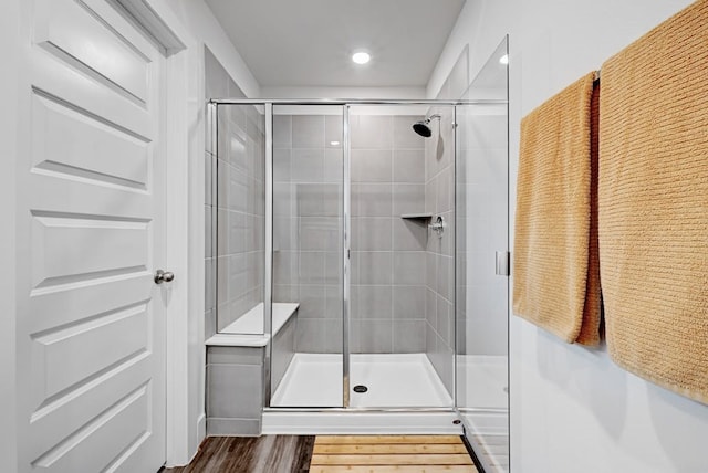 bathroom featuring hardwood / wood-style flooring and walk in shower