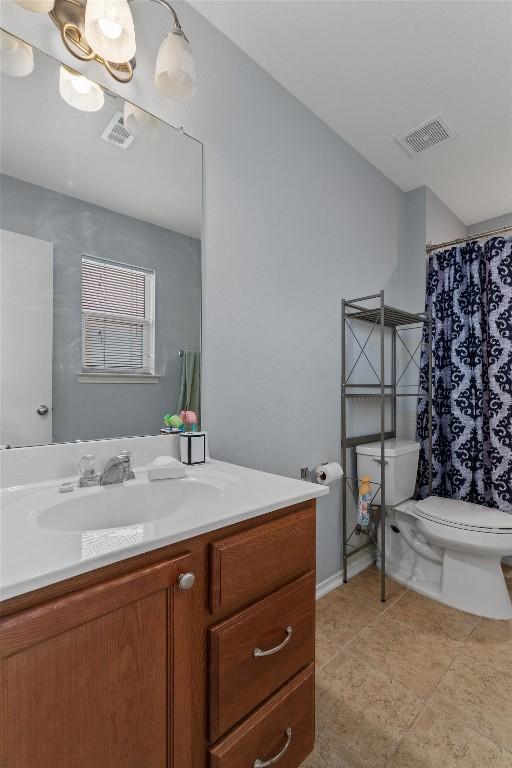 bathroom with tile patterned flooring, vanity, and toilet