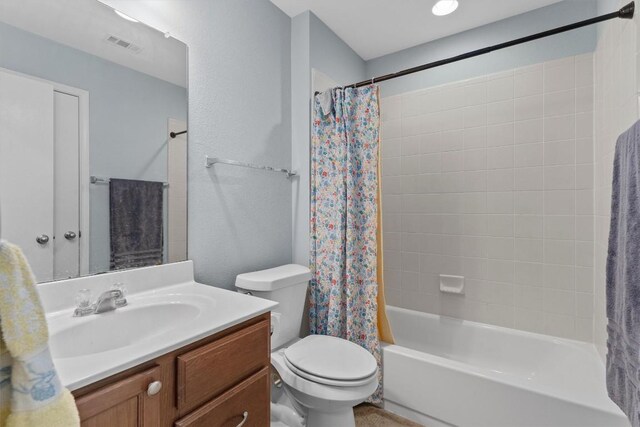 full bathroom with vanity, shower / bath combination with curtain, and toilet