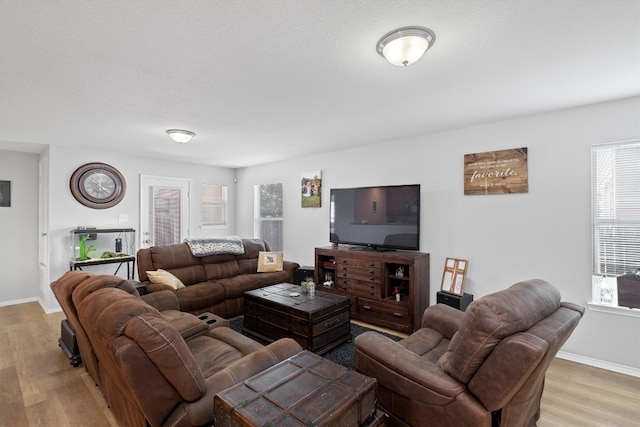 living room with light hardwood / wood-style floors and a textured ceiling