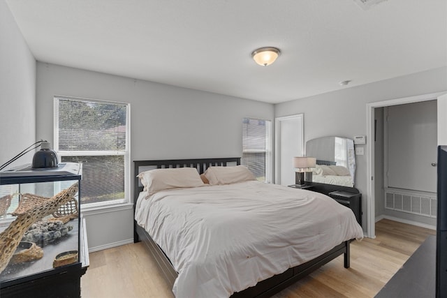 bedroom with multiple windows and light hardwood / wood-style floors