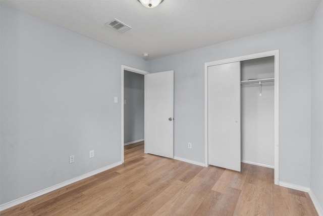 unfurnished bedroom featuring light wood-type flooring and a closet