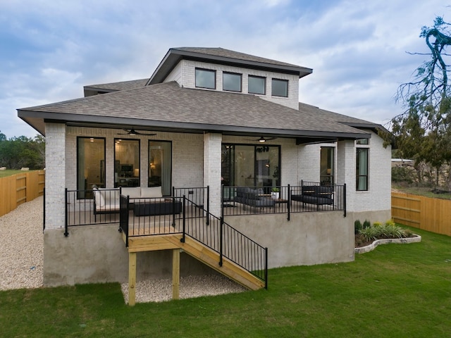 back of property featuring ceiling fan and a yard