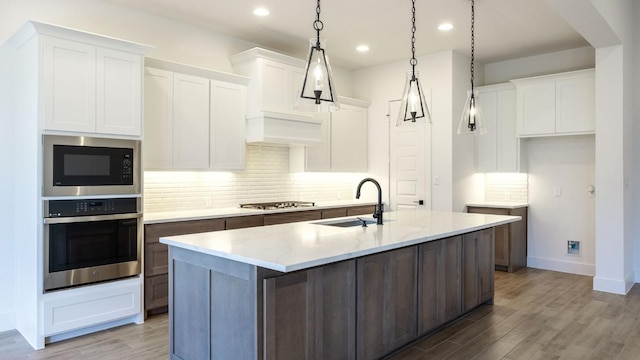 kitchen featuring white cabinetry, an island with sink, stainless steel appliances, and sink