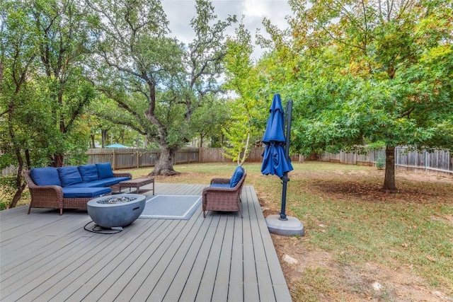 wooden deck with a lawn and an outdoor living space with a fire pit